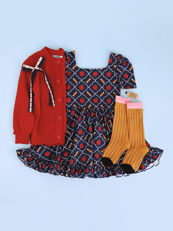 girls' navy apple and pencil print twirl dress paired with bright red cardigan, pencil knee socks and blue lace hair bow with school themed ribbon detail