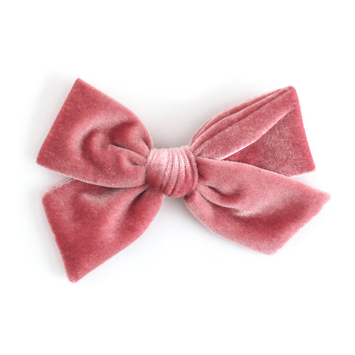 A dusty rose velvet bow hair clip on a clean white background.