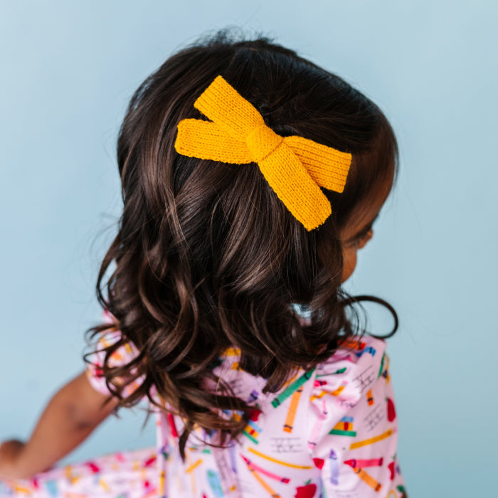 little girl in marigold yellow yarn bow on clip and matching school themed twirl