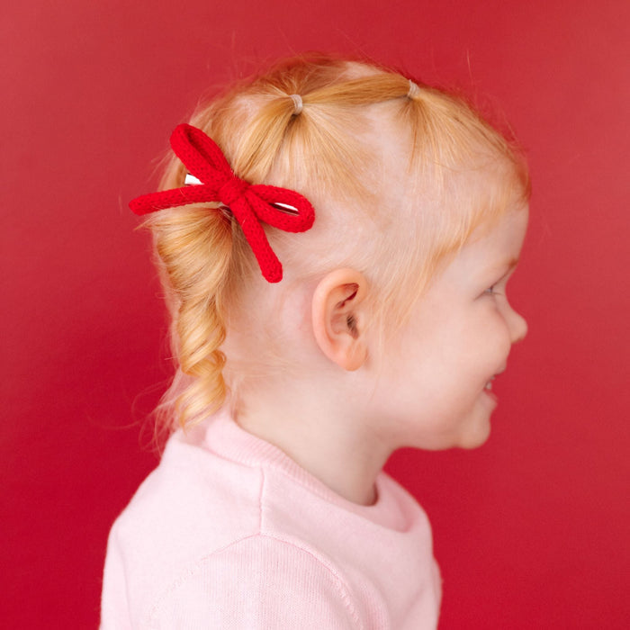 little girl in made to match bright red knit pigtail bows on clips for